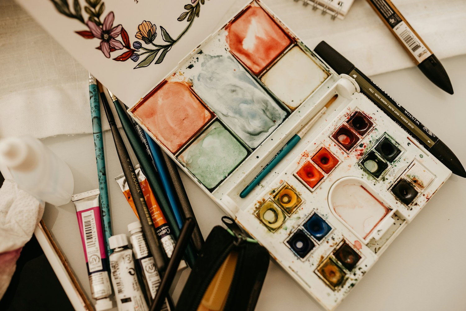 Watercolor paints and brushes on an artist’s table